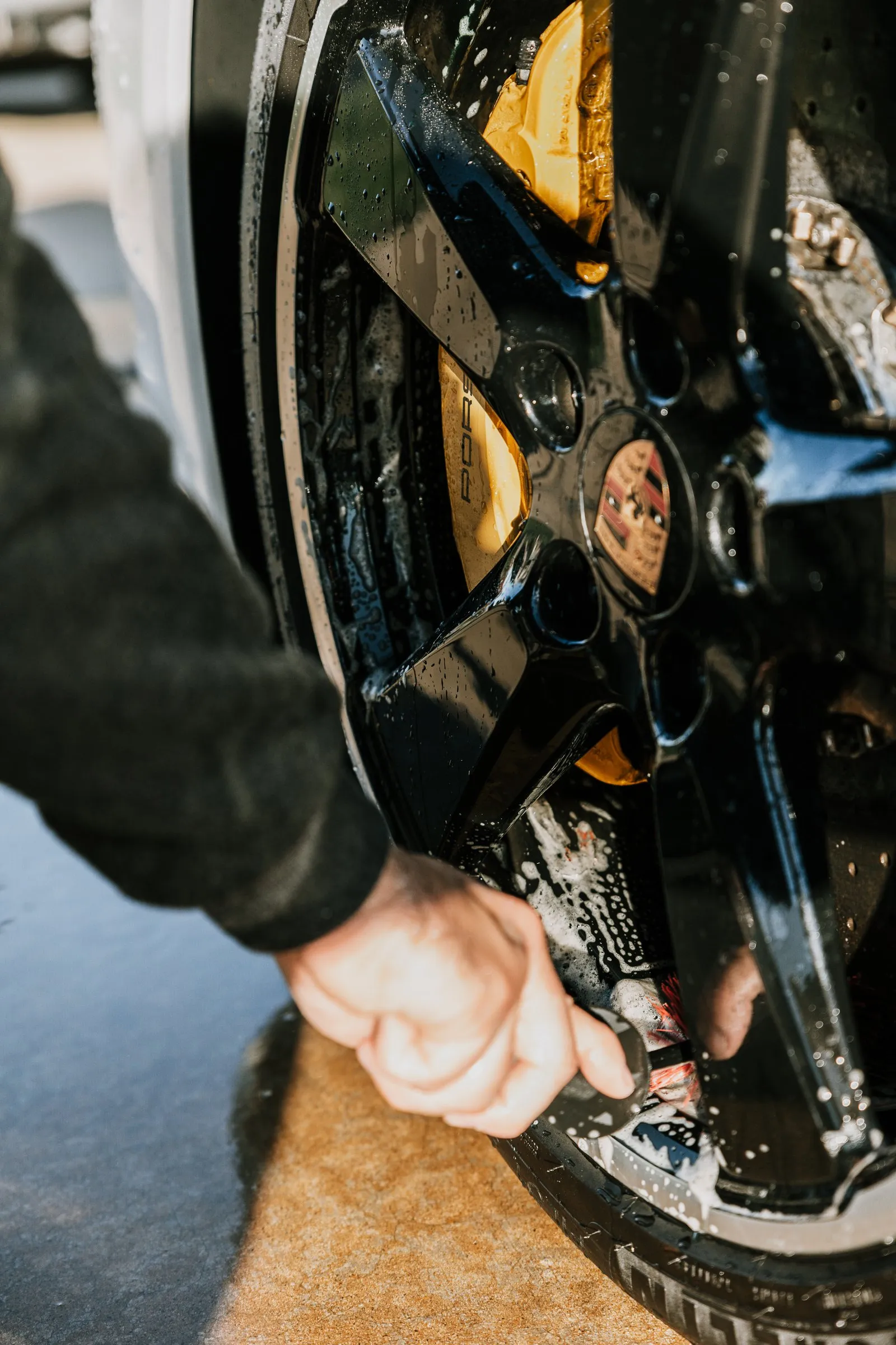 Yellow brake caliper cleaned behind the spokes of a wheel