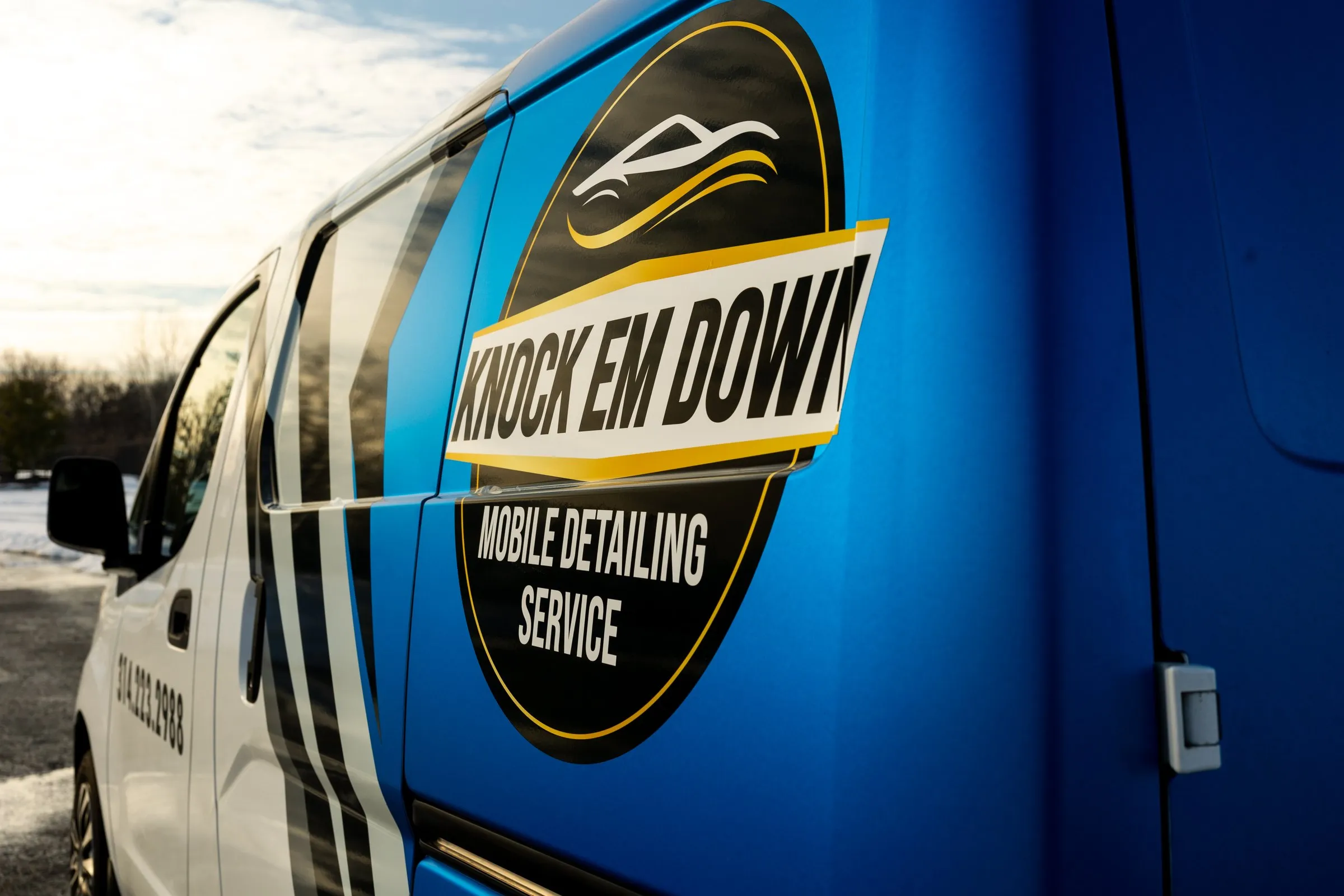 The Knock Em Down logo on the side of the work van
