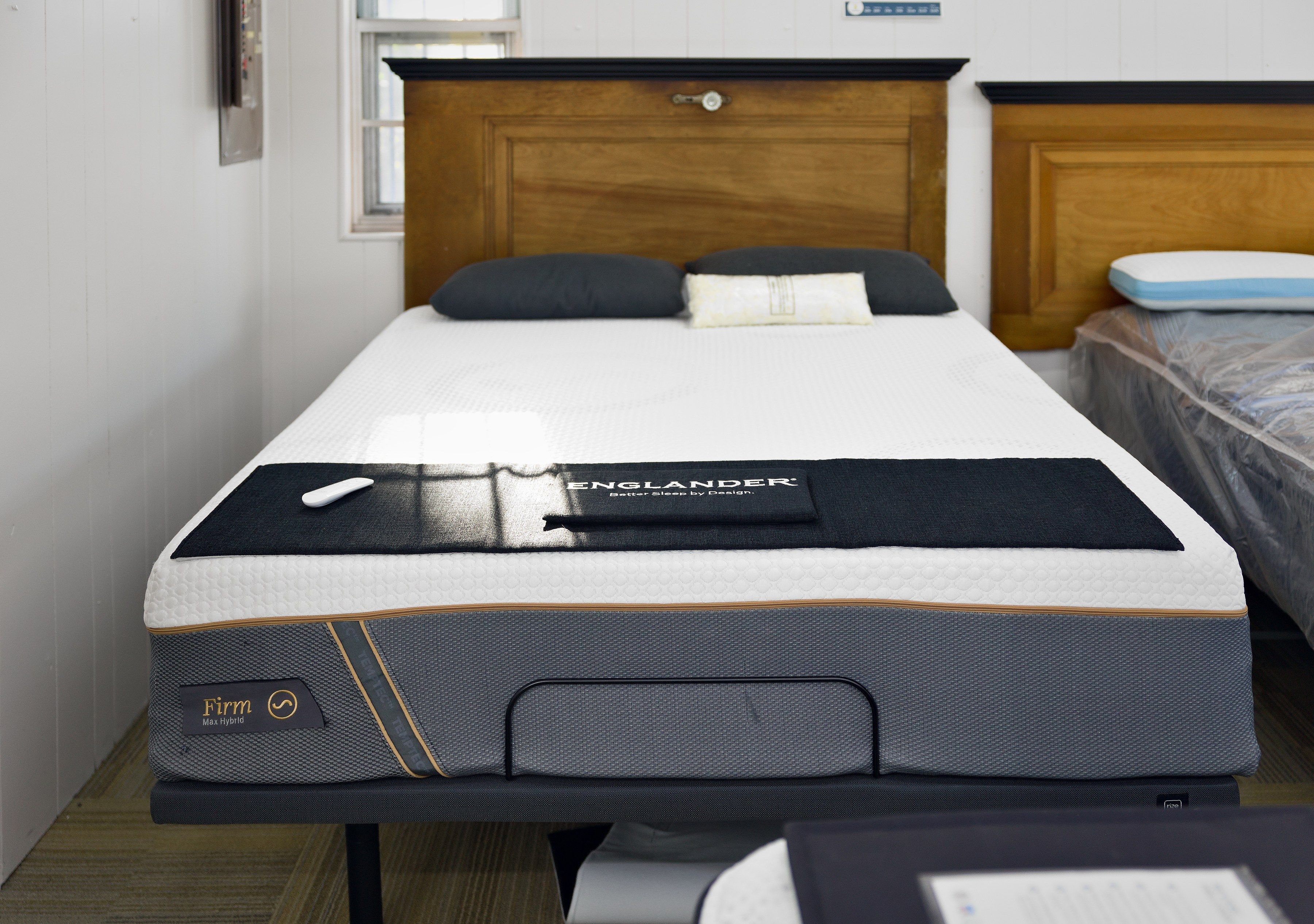 An Englander mattress on an adjustable base in the showroom, under a wood headboard