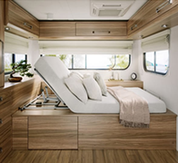 An Uplift base with the head raised, on a bed in a camper with wood cabinets