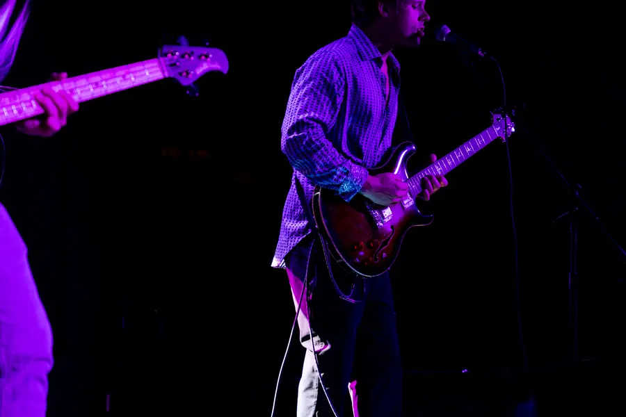 A guitarist under deep purple light.