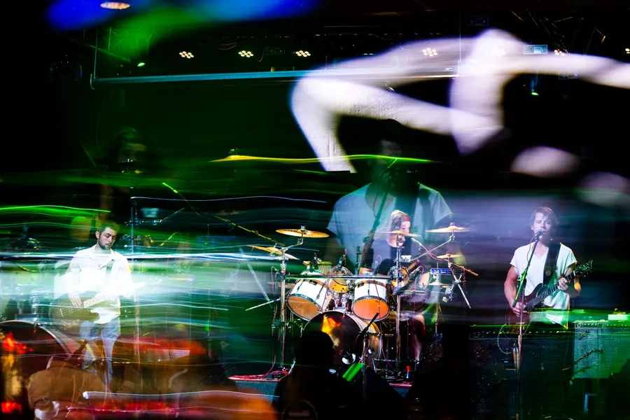 The band smeared into green light on a long exposure.