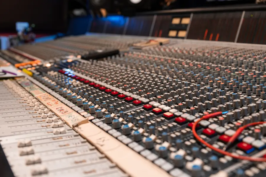 A large analogue mixing console raking away in shallow focus.